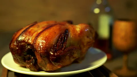 Roasting chicken rotating with white plate and beverage Stock Footage 234164795