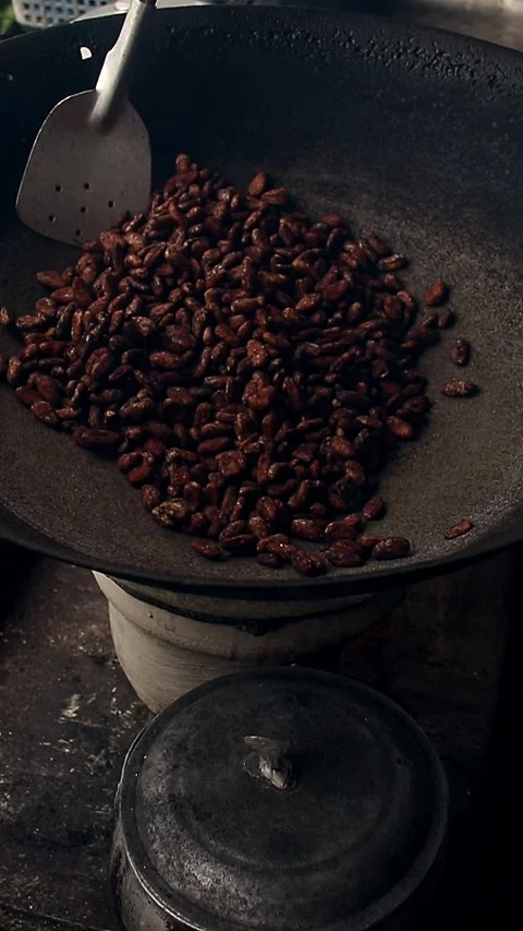 Roasting cocoa seeds on a kawa or cauldron Stock Footage 251728077