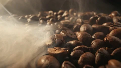 Roasting coffee beans with smoke on dark background. Smoke comes from fresh Video stock 232777329