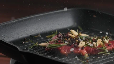 Roasting delicious meat steak in grill skillet or pan with oil and spices Stock Footage 123571302