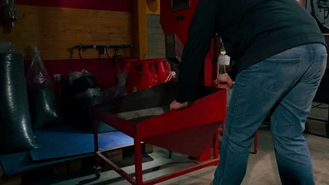 At a roasting factory, a worker uses a machine to distribute ready-made coffee Vídeo Stock 277808307