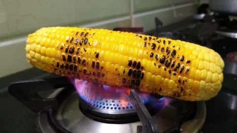 Roasting Fresh Corn on the Cob Over a Gas Stove Flame Close Up 스톡 동영상 339320957