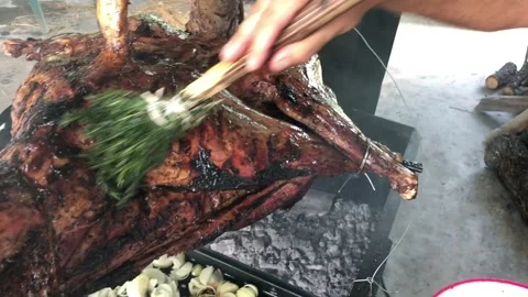 Roasting a lamb on a spit basting it with a rosemary brush 4k HD 库存影片 194990022