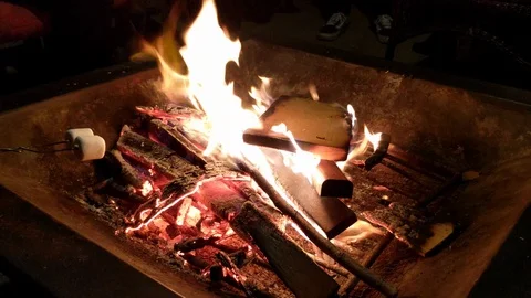 Roasting marshmallow around a firepit in the backyard at night Stock Footage 127632604
