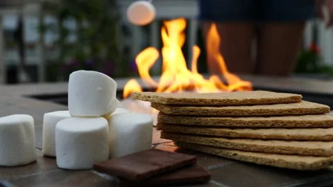 Roasting marshmallow over fire pit to make a s'more chocolate and graham cracker Stock Footage 205164771