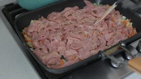 Roasting meat at high speed. Cooking goulash, stirring meat pieces in a frying Stock Footage 266898655