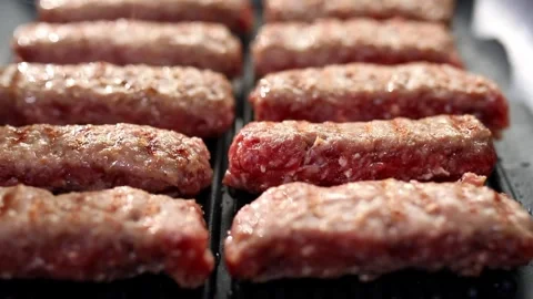 Roasting meat. Smooth camera movement over a frying pan with steaming sausages. Stock Footage 244335033