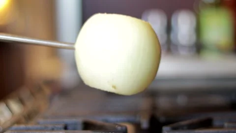 Roasting onion over burner in a kitchen Video stock 139015329