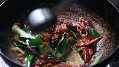 Roasting onions, dried red chilli and curry leaves in oil to make tadka. Tadk 動画素材 138515880