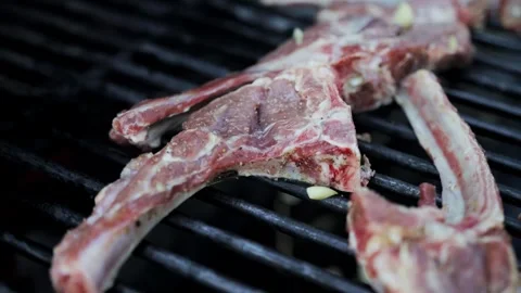 Roasting pork ribs on a grill grate in a barbecue oven, slow motion, close-up 스톡 동영상 318287211