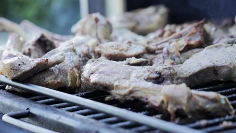 Roasting pork ribs on a grill grate in a barbecue oven, slow motion Stock Footage 322092939