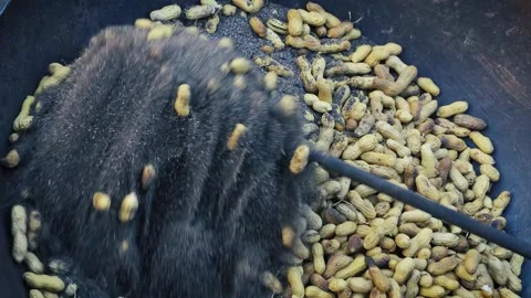 Roasting raw peanuts in hot sand at street stall India Stock Footage 319074326