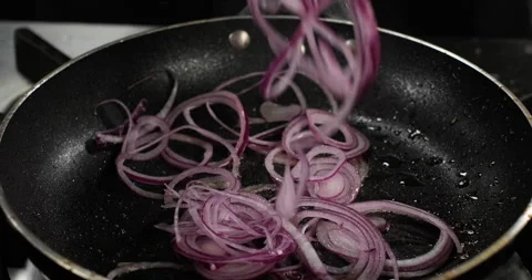 Roasting red onion in a frying pan on a gas stove. Close-up sliced onion Stock-Footage 295956801