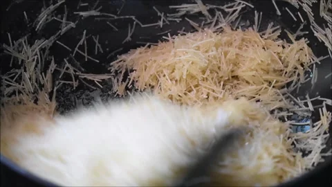 Roasting semiya or Vermicelli in ghee for making samiya payasam. Payasam is a Stock Footage 138512033