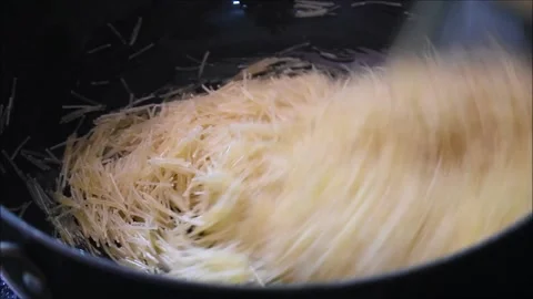 Roasting semiya or Vermicelli in ghee for making samiya payasam. Payasam is a Stock Footage 138513974