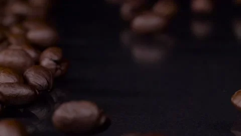 Roasting. Slow motion shot of fresh roasted brown coffee beans rolling, falling Video stock 147412962