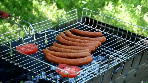 Roasting vegetables on the grill The cook puts tomatoes, zucchini on the grill Stock Footage 203809381
