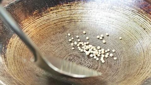 Roasting white peppercorns in a pan with a spatula. Stock Footage 342393577