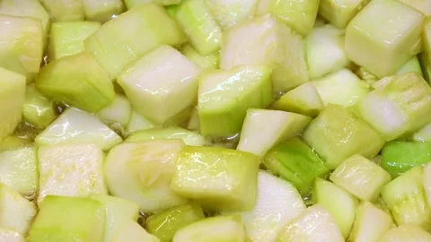 Roasting zucchini cube pieces with boiling cooking oil in a pan close up Stock Footage 264966434