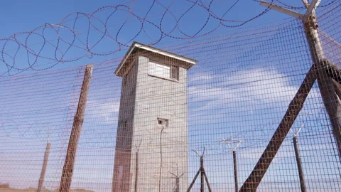 Robben Island prison tower surrounded by fencing and razor-wire Stock Footage 242014717