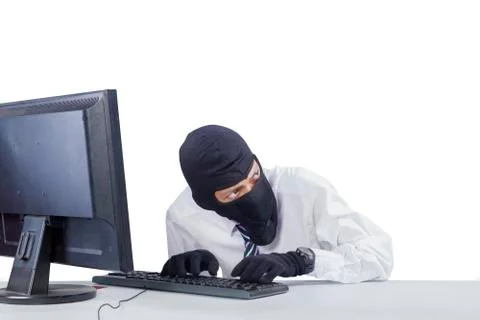 Robber with mask hacking a computer Stockfoto's
