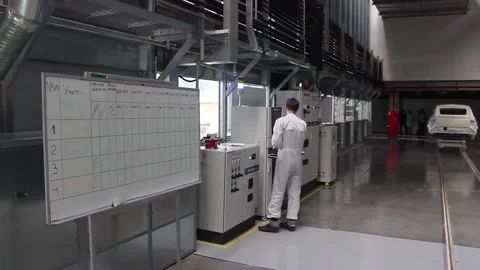 Robot 10An engineer in a white uniform moves away from the control panel Stock Footage 122335654