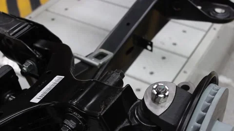 Robot 40A mechanic on a car assembly line tightens a bolt. Stock Footage 122335806