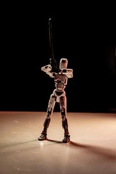 Robot Action Figure Posing with Sword in Dramatic Lighting Stock Photos
