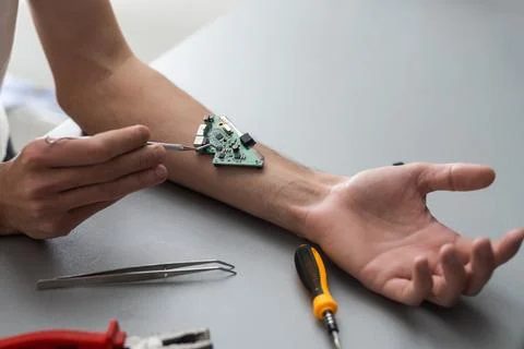 Robot arm concept. Man shows biomechanical prosthetic hand. Guy repairs his hand Stock Photos