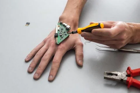 Robot arm concept. Man shows biomechanical prosthetic hand. Guy repairs his hand Stock Photos