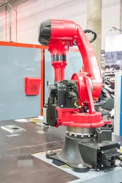 Robot arm in industrial workshop, showcasing advanced machinery, red roboti.. Stock Photos