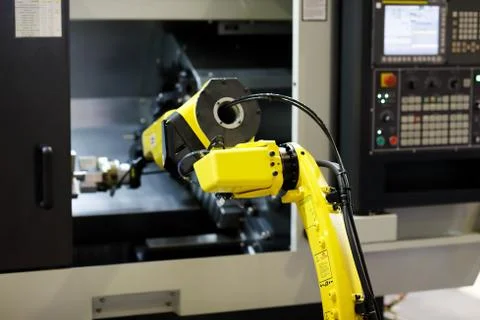 Robot arm is loading detail into CNC lathe machine Stock Photos