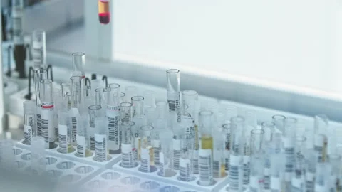 Robot arm picking up one vial from among many others. Test tubes moving in the Stock Footage 232489323