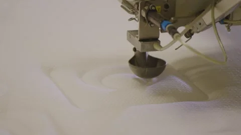 Robot arm sewing intricate patterns on a mattress in a factory, close-up Stock Footage 270105517