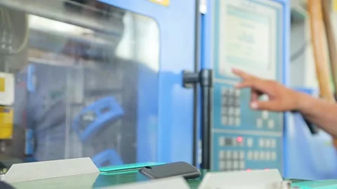 Robot arm takes plastic part out of the molding machine and puts it on conveyor Stock Footage 162918460