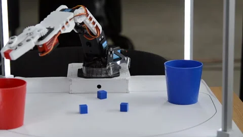 Robot automatic hand taking cubes and putting in glass. Automatic robotic arm Stock Footage 288274947