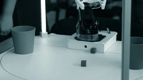 Robot automatic hand taking cubes and putting in glass. Automatic robotic arm Stock Footage 298623470