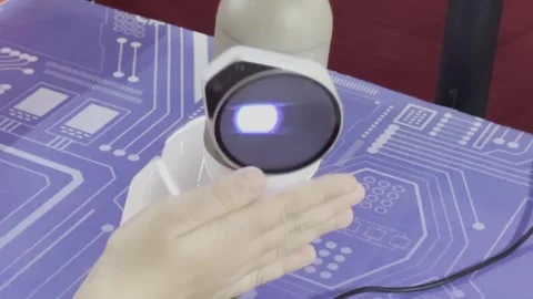 A robot is being controlled by a person's hand Vidéo 283486357