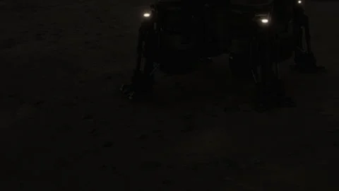 Robot explores surface of a dark and rocky landscape during a mission Stock Footage 345064215