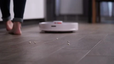 Robot facuum cleaner picking up debris from floor Stock-Footage 145018349