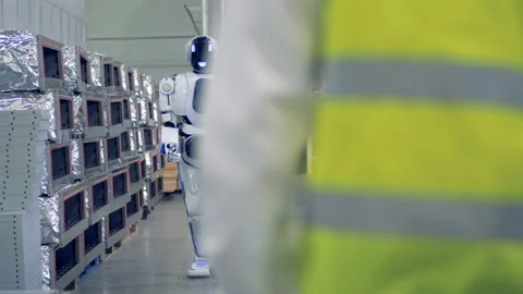 A robot goes towards a man and gives him a hi-five. Video stock 88876145