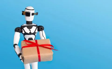 Robot holding gift box with red ribbon on blue background Stock Photos