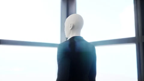 A robot humanoid staying in the empty office and looking out the window at the Stock Footage 255675172
