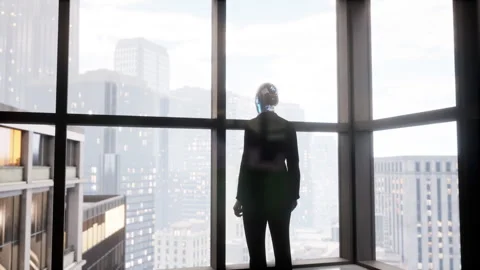 A robot humanoid staying in the empty office and looking out the window at the Stock Footage 256139613