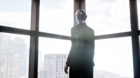 A robot humanoid staying in the empty office and looking out the window at the Stock Footage 256577061