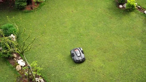 Robot lawn mower drives through the lawn from one side to the other. Stock Footage 221790480