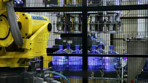Robot loader moving pure water bottles from conveyor Stock Footage 71201447