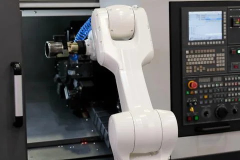Robot loading the workpiece into CNC lathe machine Stock Photos