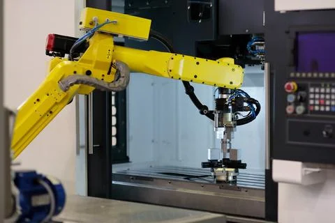Robot loading workpieces into CNC machining center Stock Photos