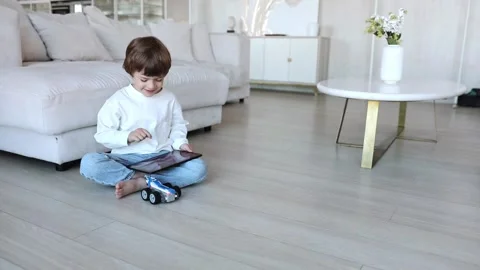 Robot made of bricks is controlled by a kid programmer, who uses tablet pc Stock Footage 254366542
